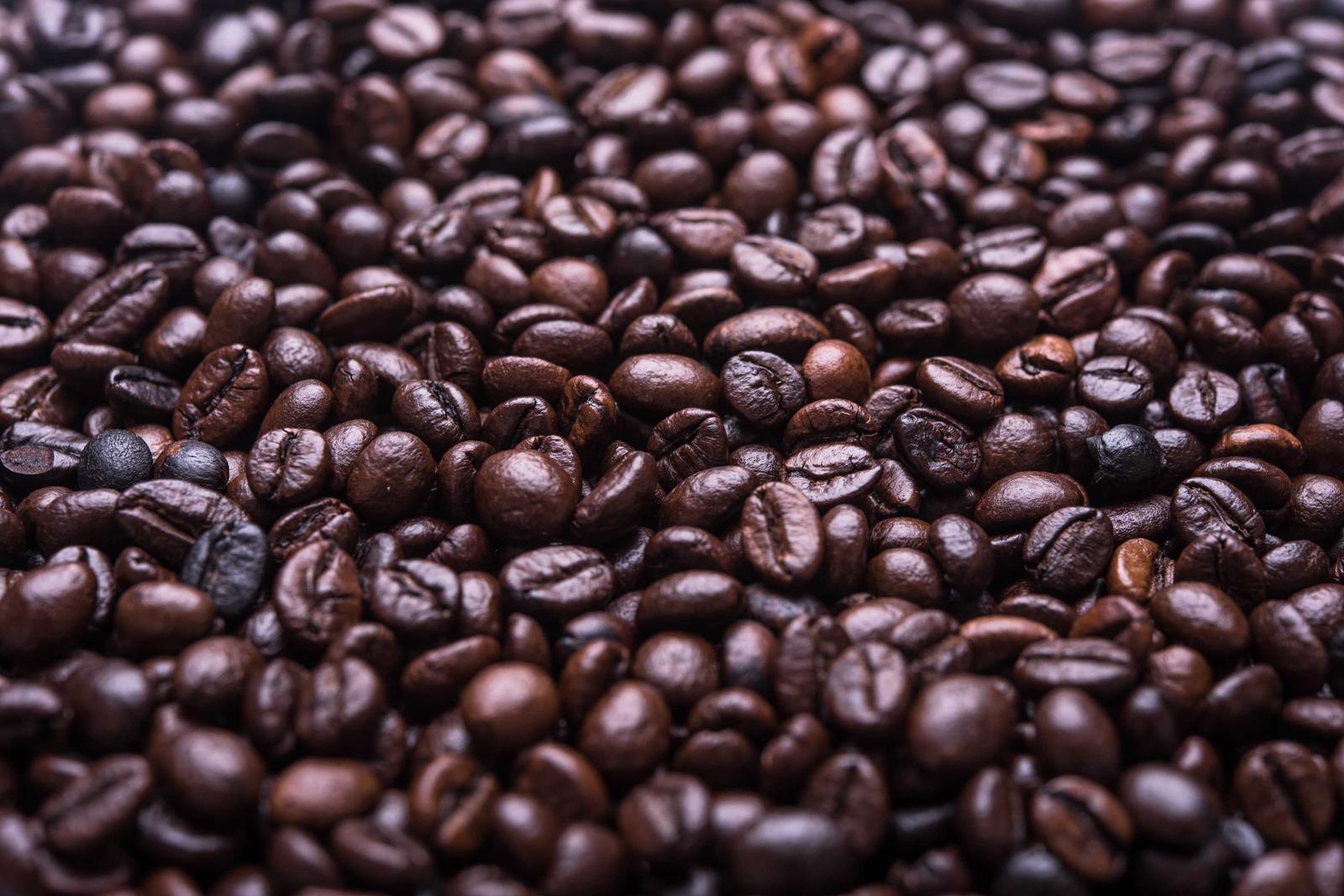Close view of a heap of freshly roasted dark coffee beans